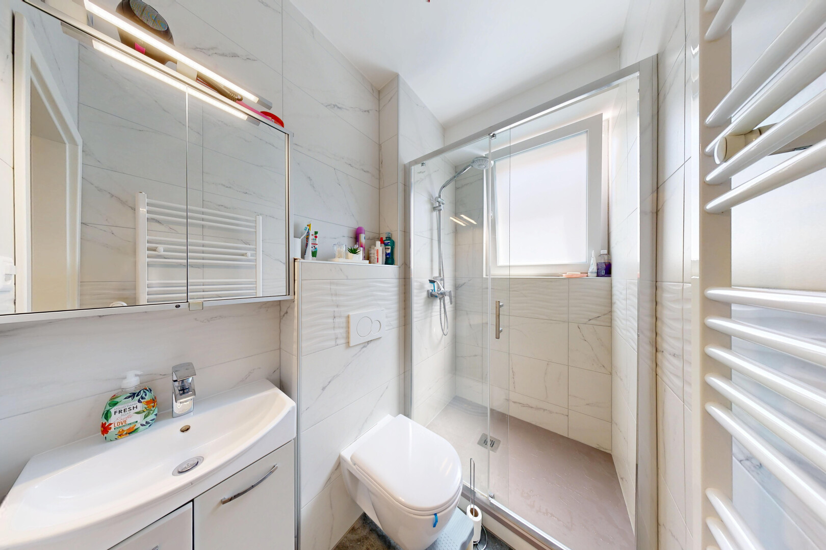 salle de bains avec chauffe-serviettes, radiateur, miroir, salle de bain complète, et douche