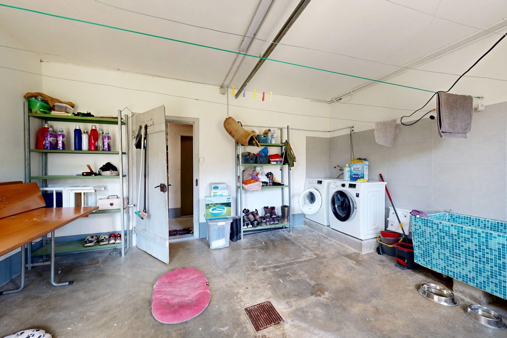 buanderie avec sol en béton, concrete floor, unfinished concrete floor, inside property, et lave-linge et sèche-linge séparés