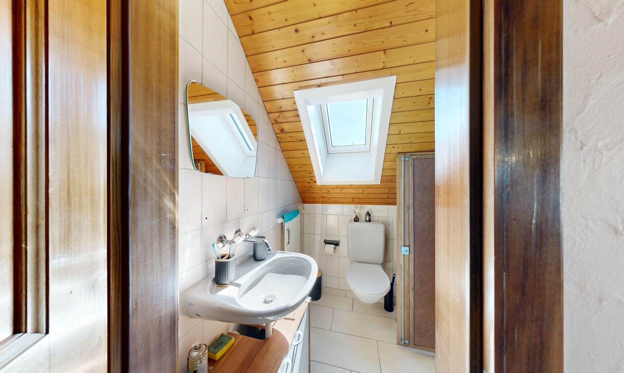 salle de bains avec plafond voûté, vaulted ceiling, miroir, inside property, et évier