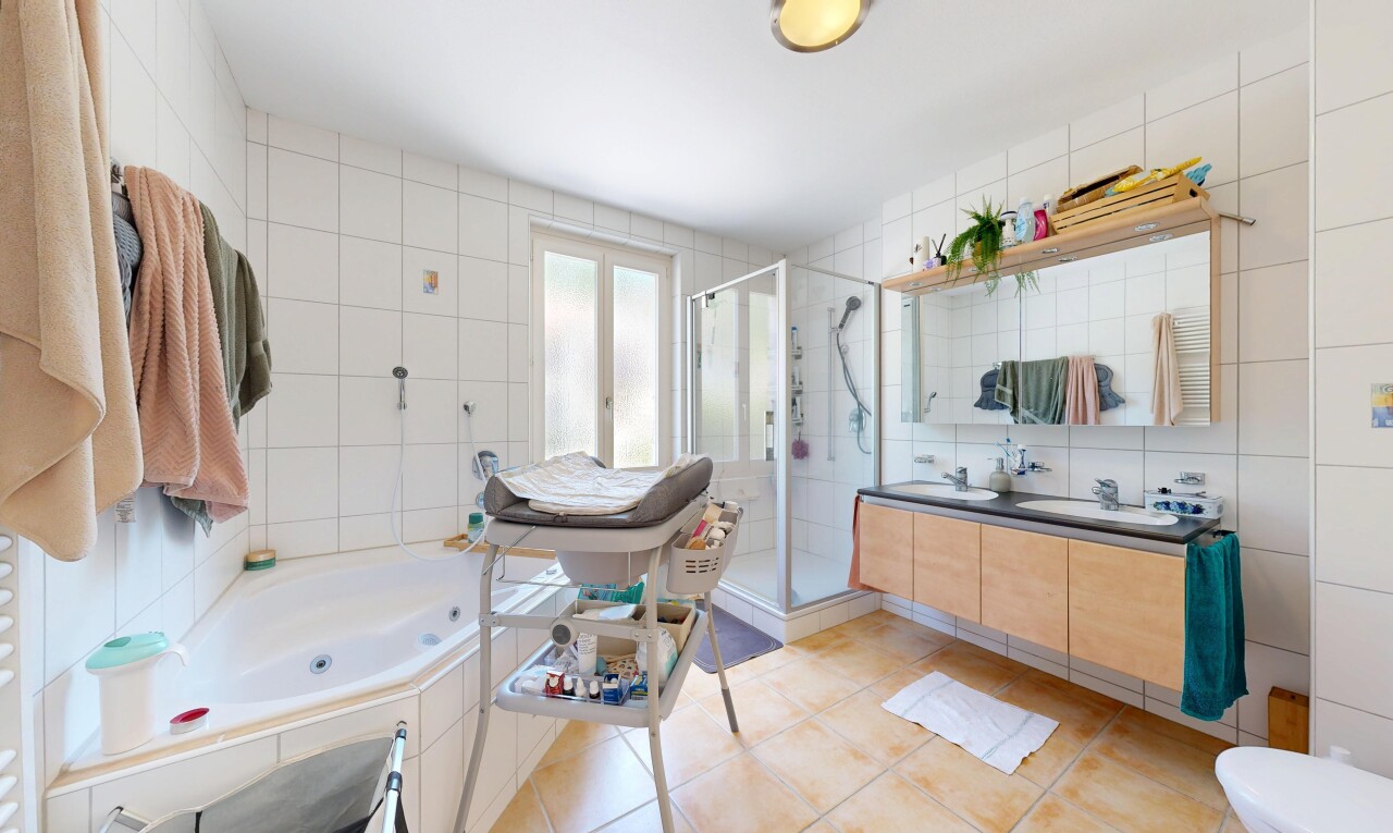 salle de bains avec mur en carrelage, tile wall, bain, double vasque, et douche