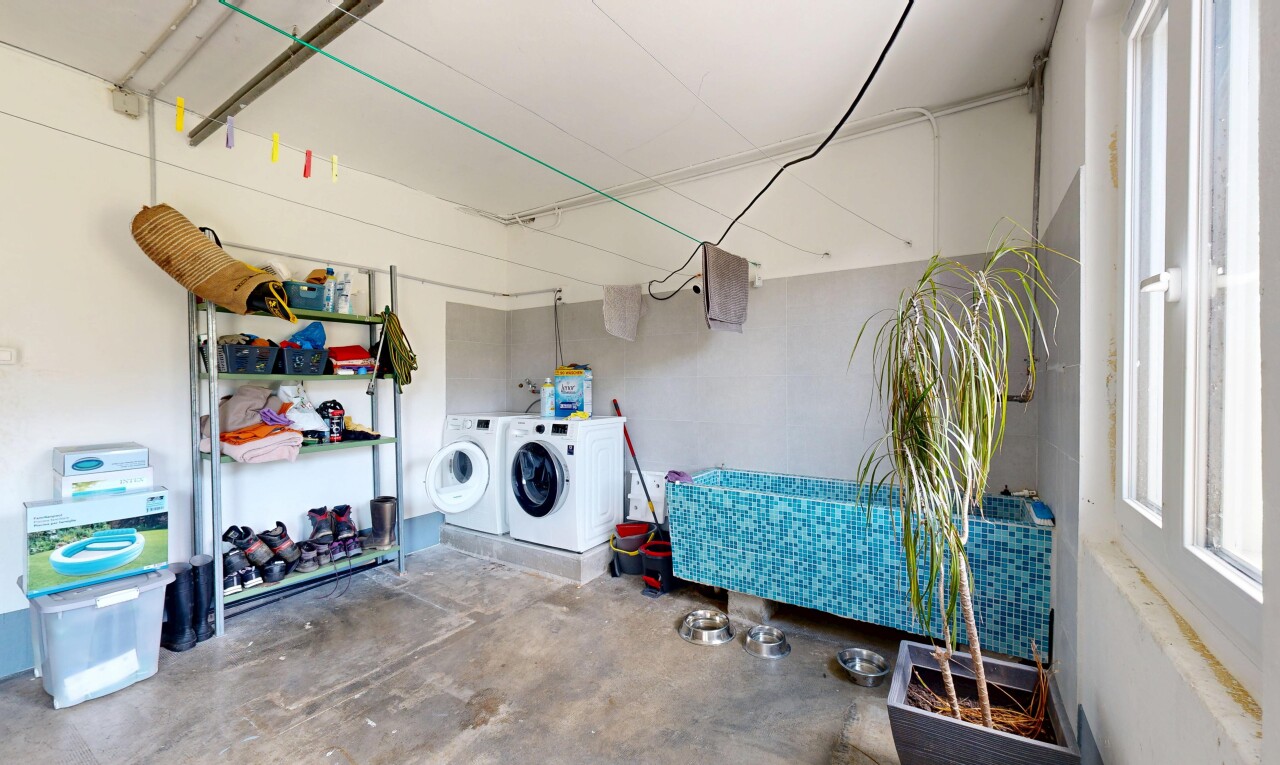 buanderie avec sol en béton, concrete floor, unfinished concrete floor, inside property, et lave-linge et sèche-linge séparés