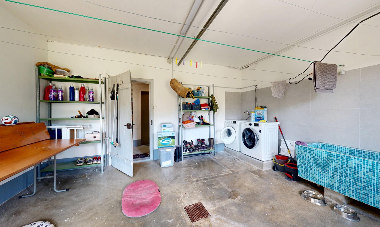 buanderie avec sol en béton, concrete floor, unfinished concrete floor, inside property, et lave-linge et sèche-linge séparés