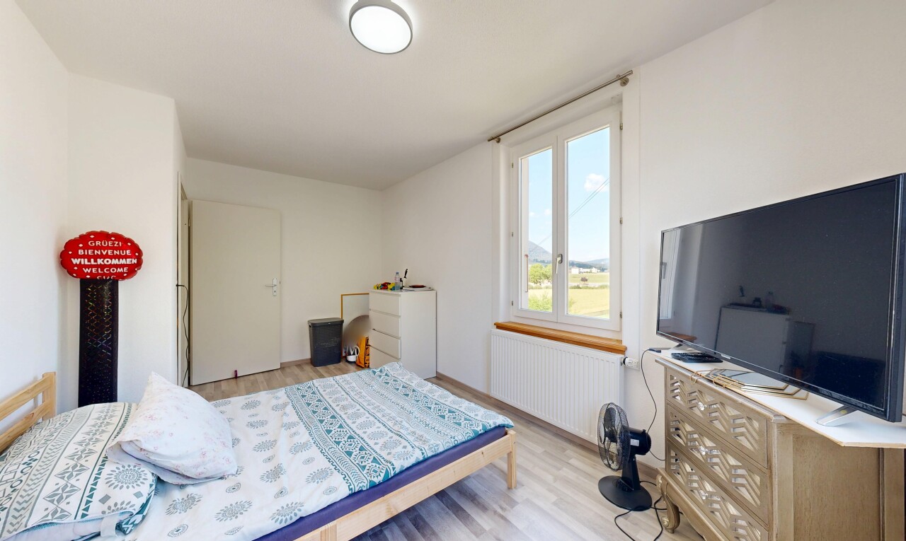 chambre avec radiateur, sol en finition bois, wood finish floor, inside property, et télévision