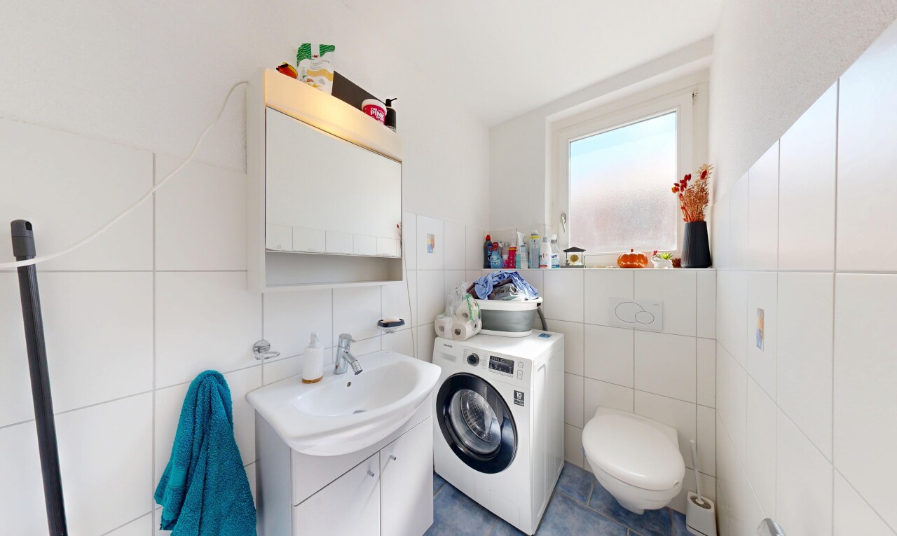 salle de bains avec lavabo (ou coiffeuse selon le contexte), miroir, lave-linge et sèche-linge, inside property, et toilette