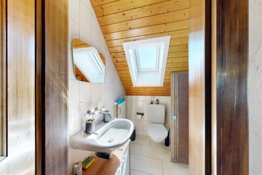 salle de bains avec plafond voûté, vaulted ceiling, miroir, inside property, et évier