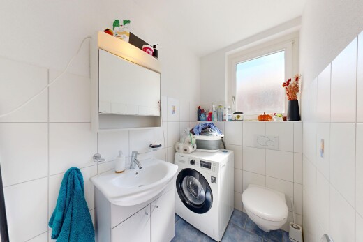salle de bains avec lavabo (ou coiffeuse selon le contexte), miroir, lave-linge et sèche-linge, inside property, et toilette