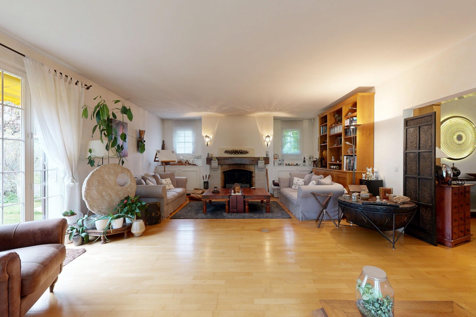 salon avec cheminée, inside property, sol en finition bois, wood finish floor, et lumière naturelle