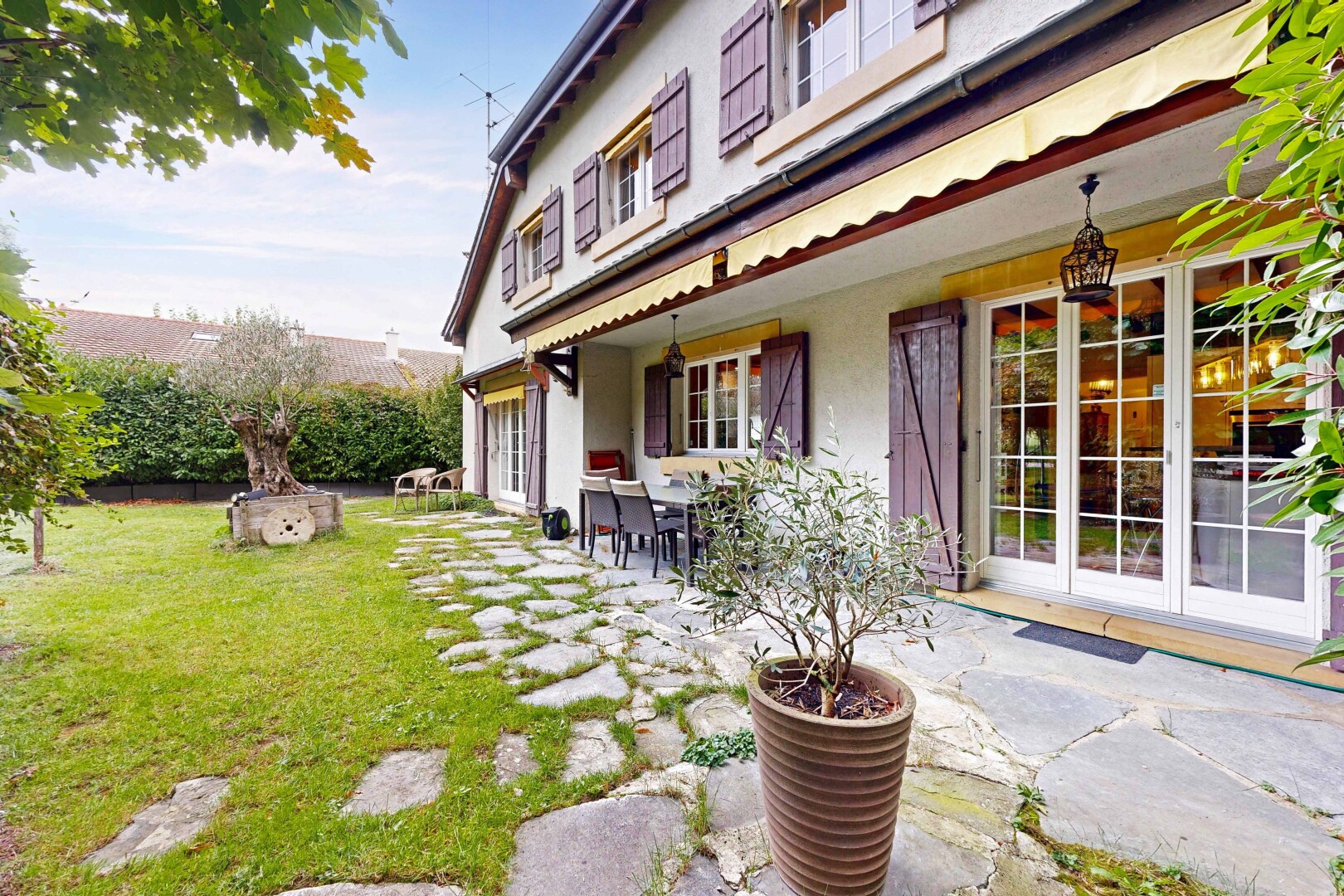 façade avec auvent, terrasse, bardage en stuc, day time, et property visible