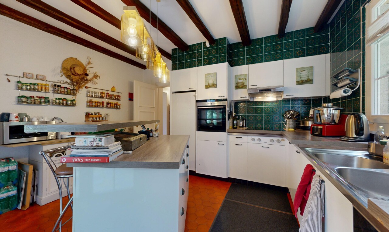 cuisine avec backsplash, armoires blanches, four, beamed ceiling, et inside community
