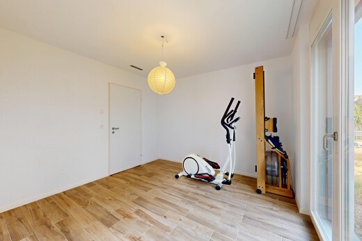 pièce vide avec éclairage suspendu, wood finish floor, sol en finition bois, drywall, et cloison sèche