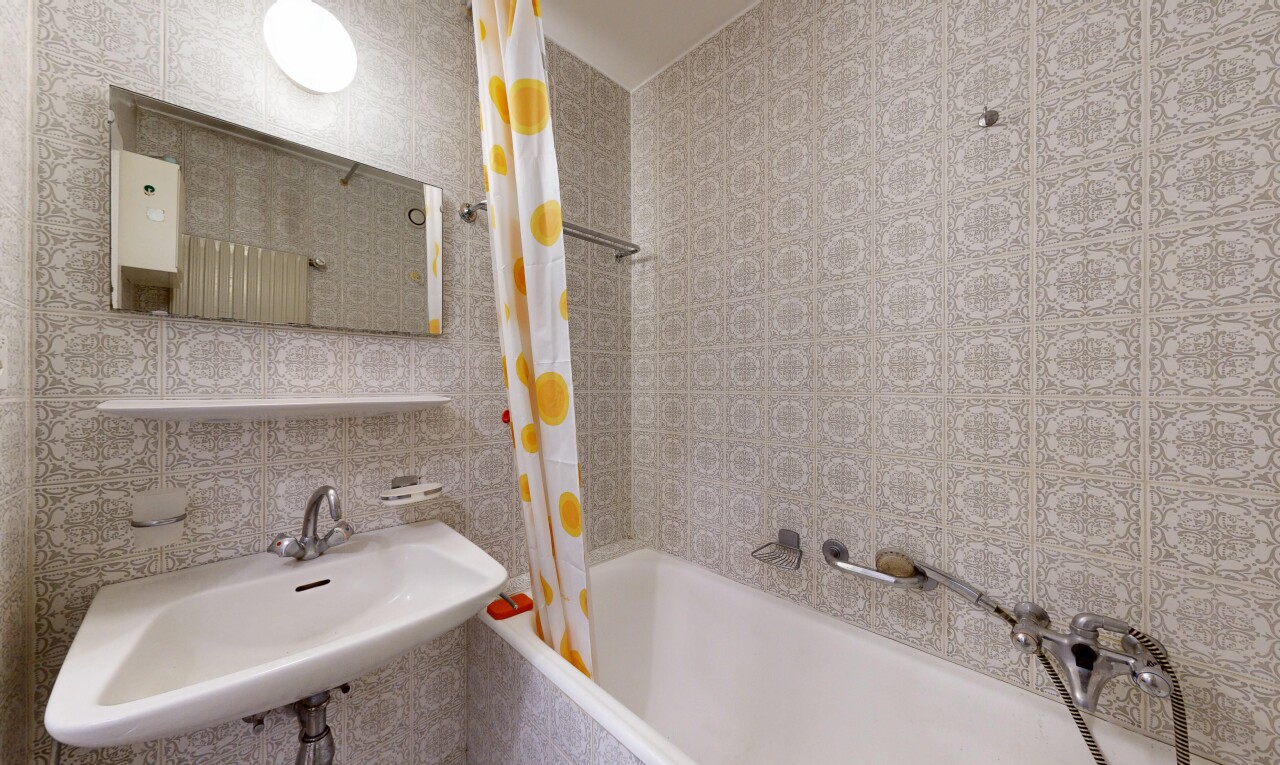 bathroom featuring tiled shower / bath combo and tile walls