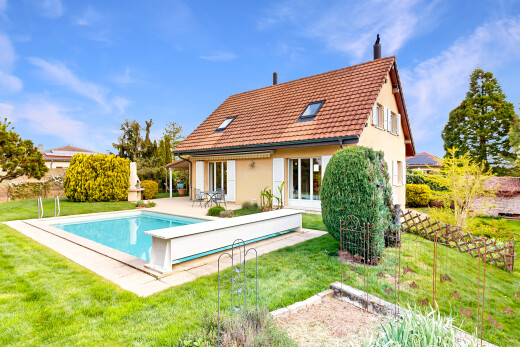 façade avec pelouse, toit en tuiles, property visible, piscine, et day time