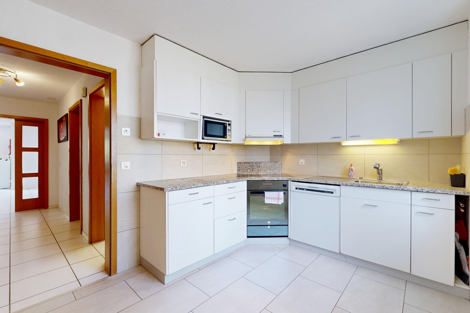 cuisine avec light floor, armoires blanches, white cabinets, light countertops, et four