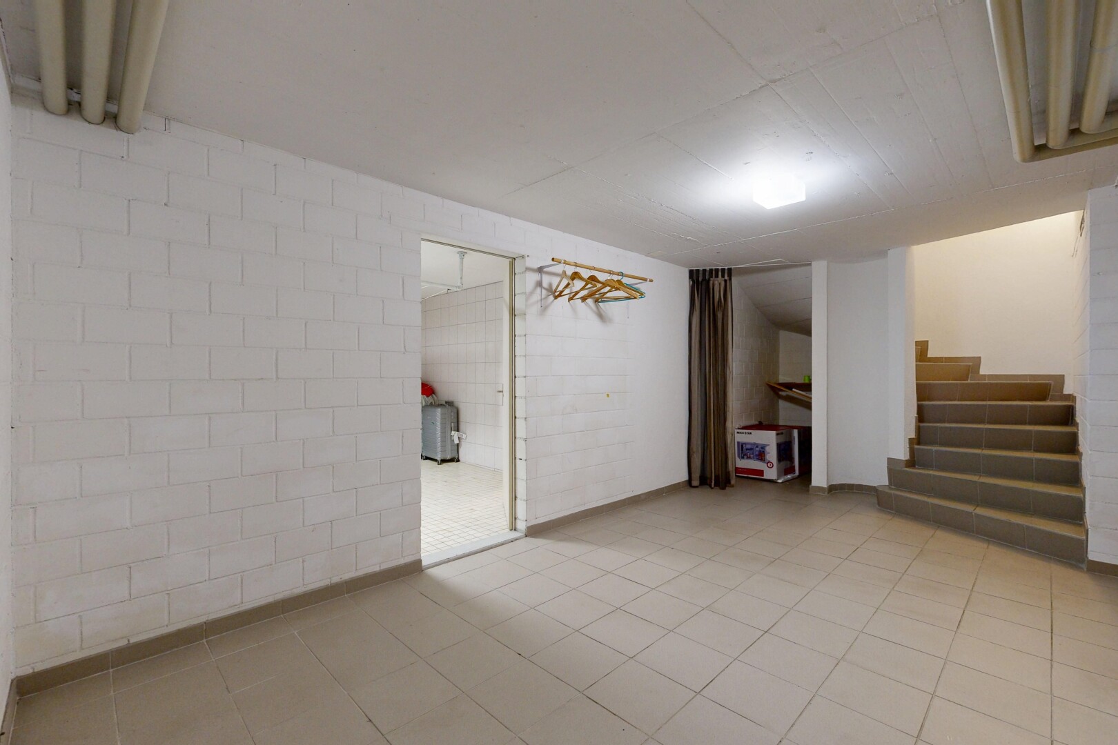 pièce vide avec escaliers, sous-sol, mur en blocs de béton, concrete block wall, et inside property