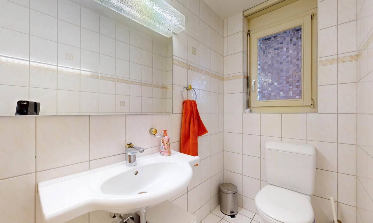 salle de bains avec mur en carrelage, tile wall, toilette, et inside property