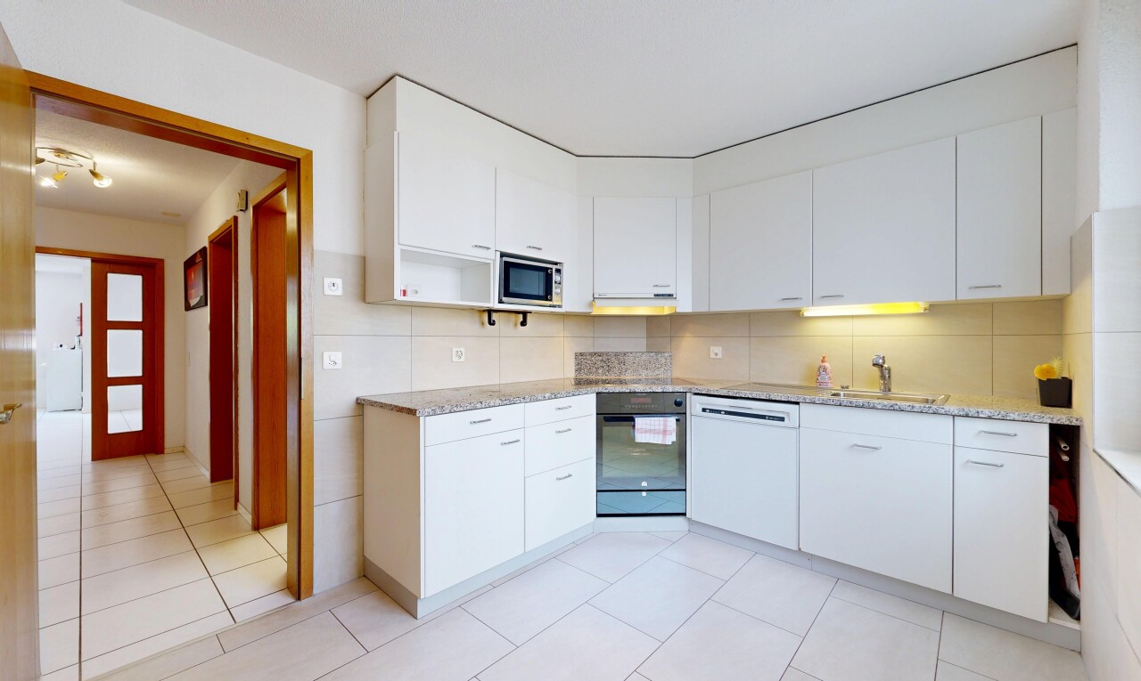 cuisine avec light floor, armoires blanches, white cabinets, light countertops, et four