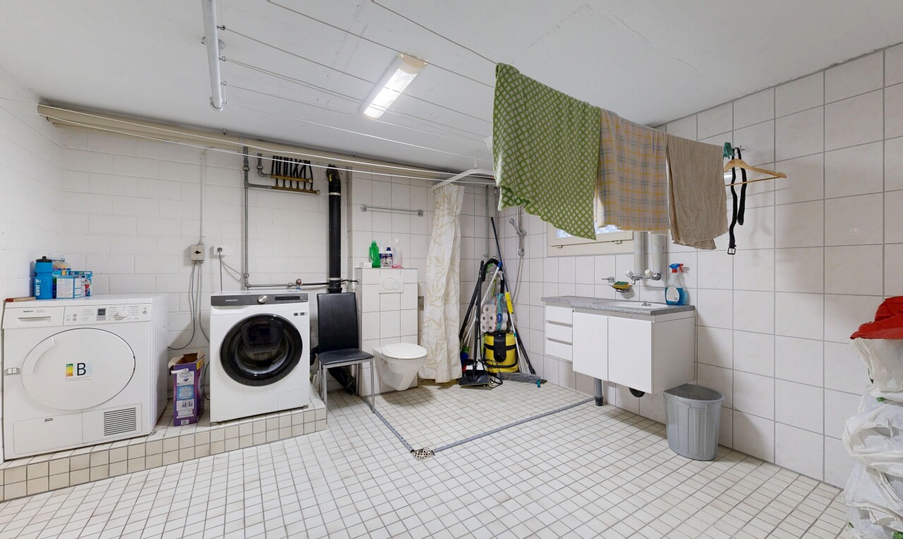 buanderie avec inside property, buanderie, mur en carrelage, tile wall, et lave-linge et sèche-linge séparés