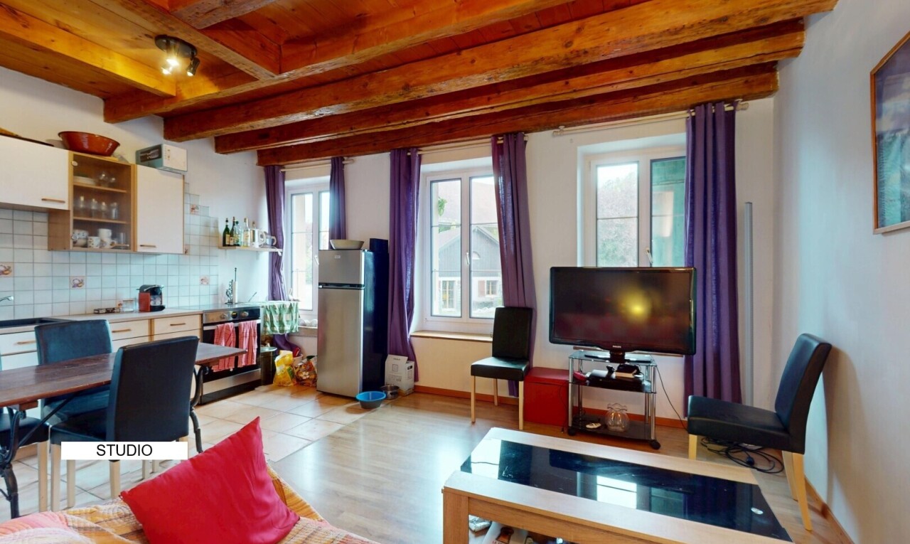 wohn- / esszimmer mit balkendecke, beamed ceiling, fernseher, inside property, und natürliches licht