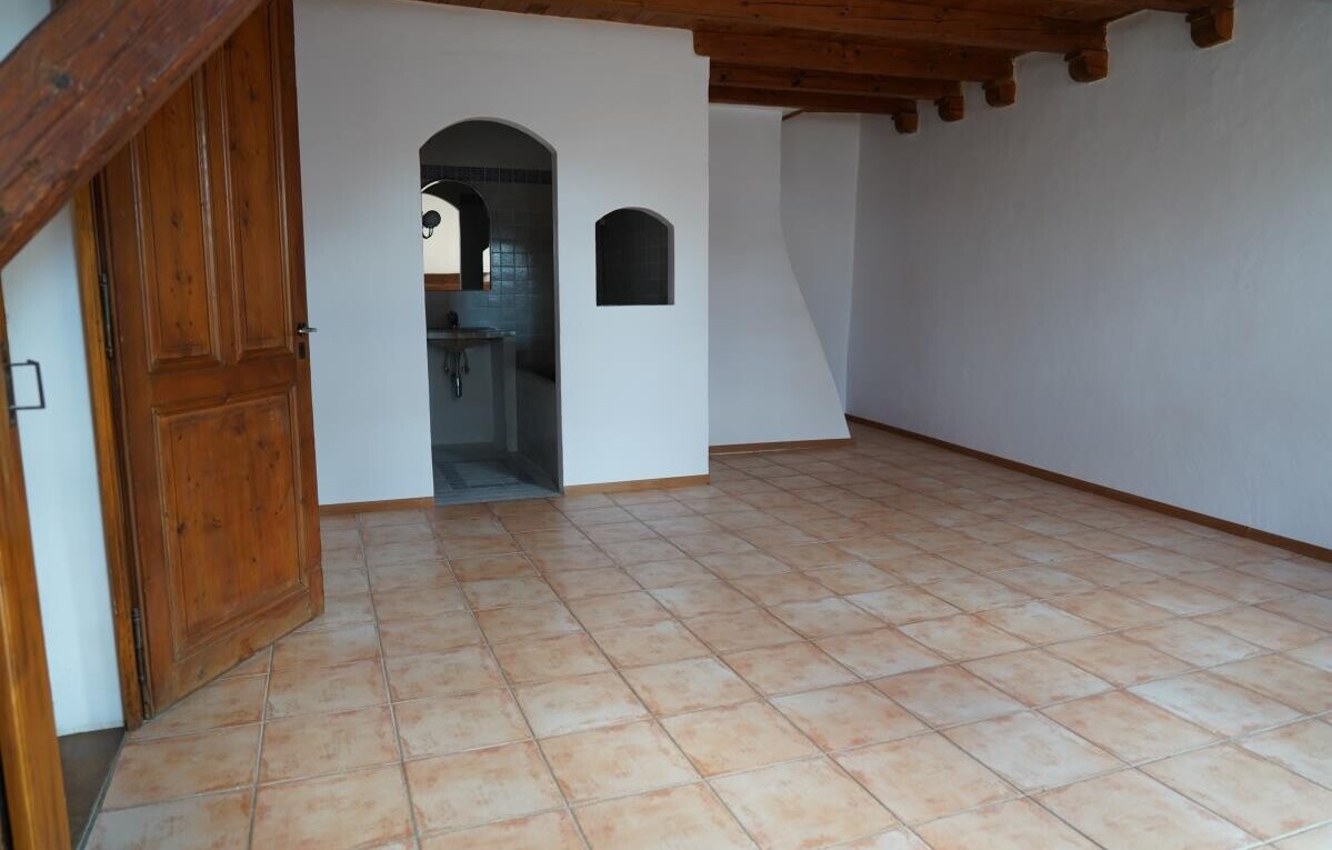 leerer raum mit gewölbte gehwege, balkendecke, beamed ceiling, gipskartonwand, und drywall