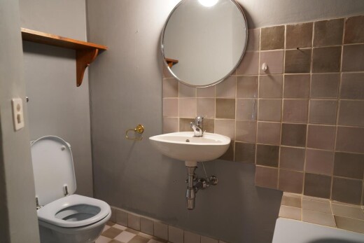 salle de bains avec miroir, backsplash, dosseret, inside property, et toilette