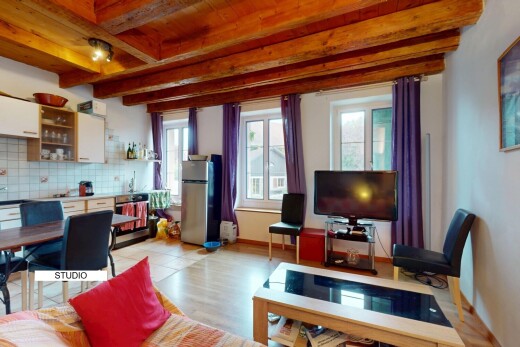 salon / salle à manger avec plafond à poutres, beamed ceiling, télévision, inside property, et lumière naturelle