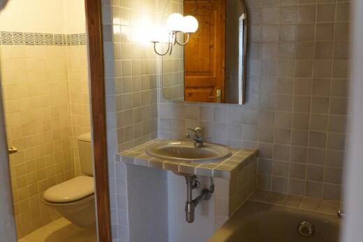 salle de bains avec tile wall, mur en carrelage, toilette, salle de bain complète, et inside property