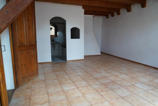 pièce vide avec passages en arc, plafond à poutres, beamed ceiling, cloison sèche, et drywall
