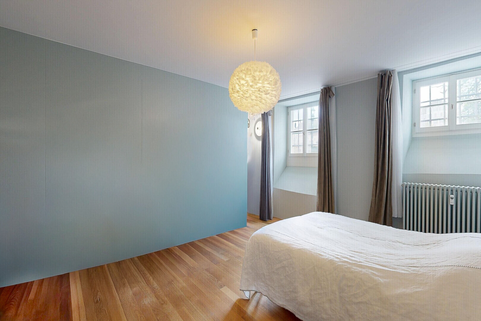 zimmer / schlafzimmer mit kühler, holzfußboden, wood finish floor, natürliches licht, und natural light