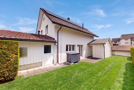 außenansicht mit property visible, rasen, solaranlage, day time, und stuckverkleidung