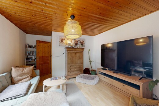 salon avec télévision, drywall, cloison sèche, wood finish floor, et sol en finition bois