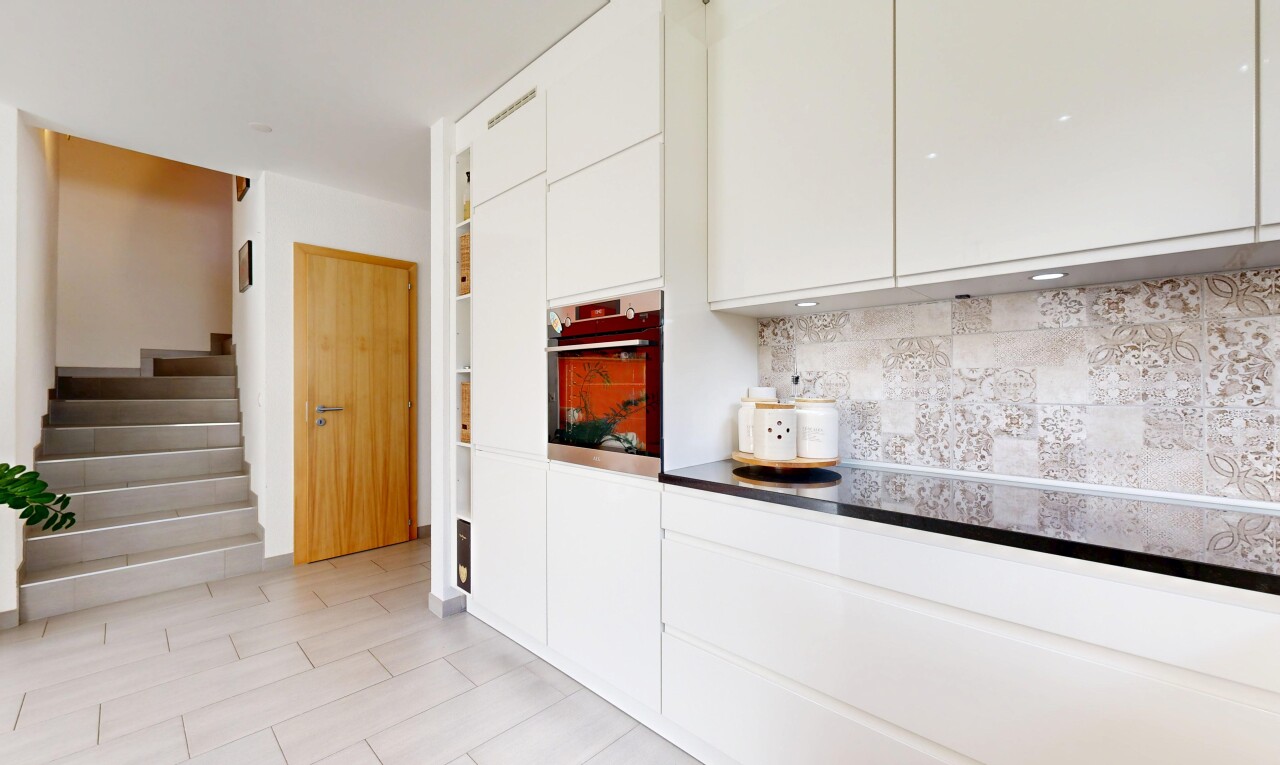 küche mit weiße schränke, schränke mit flachen paneelen, ofen, inside property, und küchenrückwand beim herd