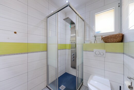 salle de bains avec tile shower, salle de bain complète, douche, inside property, et toilette