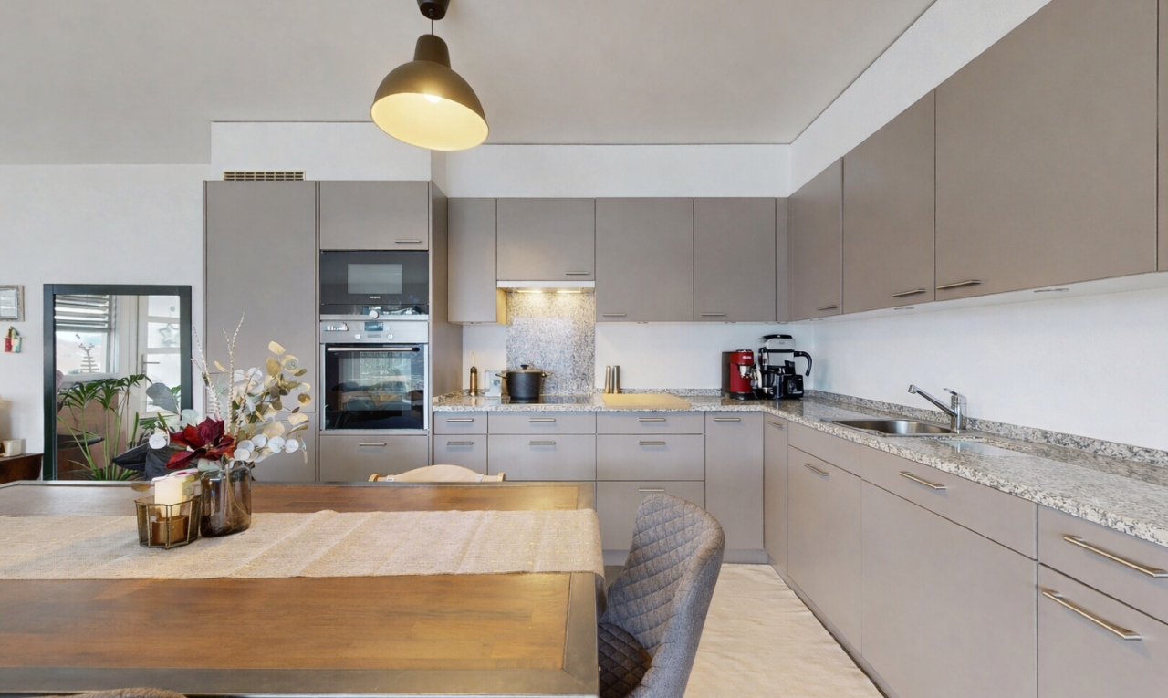 küche mit graue schränke, ofen, inside property, pendelleuchte, und drywall