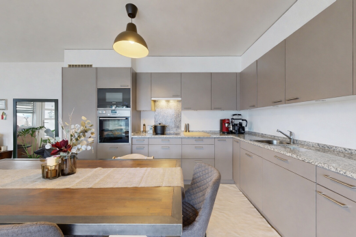 küche mit graue schränke, ofen, inside property, pendelleuchte, und drywall