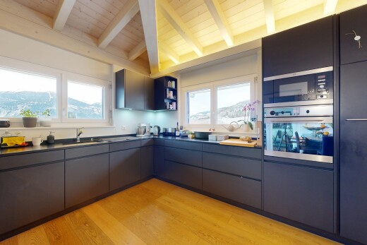kitchen featuring dark countertops, modern cabinets, appliances with stainless steel finishes, light wood-type flooring, and wood ceiling
