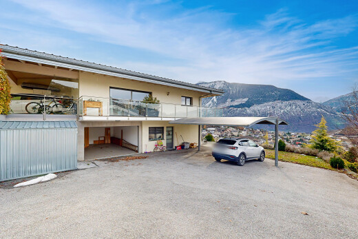 view of home with a balcony, a mountain view, a carport, and stucco siding