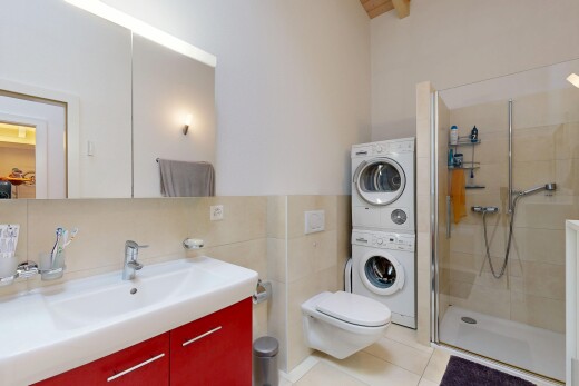 full bathroom featuring vanity, a shower stall, tile walls, estacked washer and dryer, and light tile patterned floors
