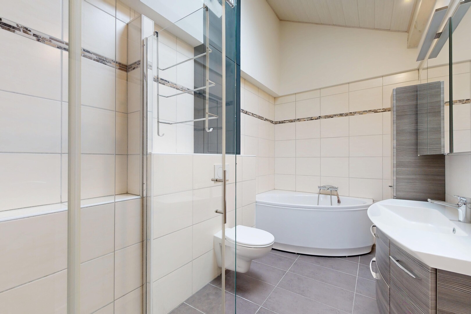 salle de bains avec salle de bain complète, lavabo (ou coiffeuse selon le contexte), miroir, tile wall, et mur en carrelage