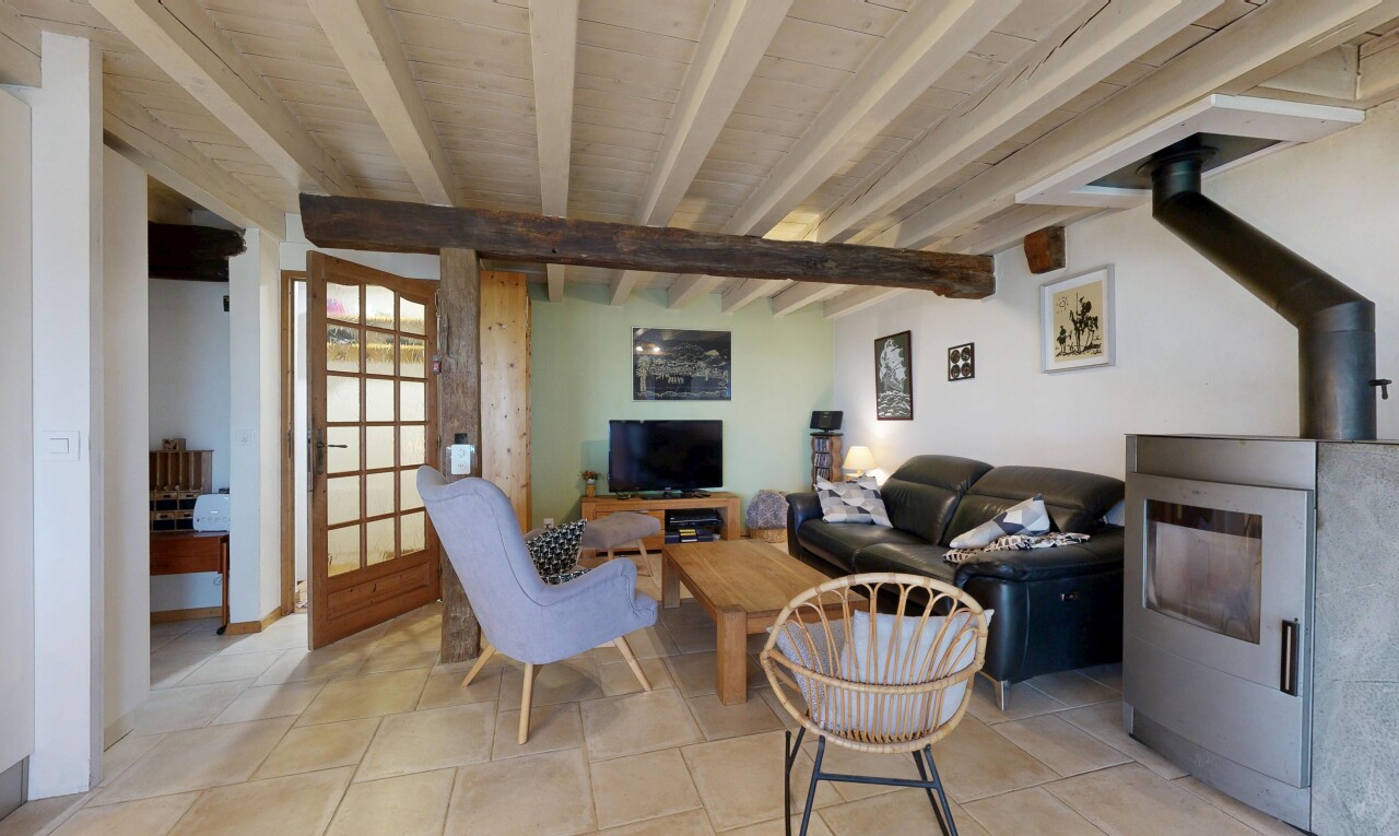 salon avec inside property, poêle à bois, télévision, beamed ceiling, et plafond à poutres