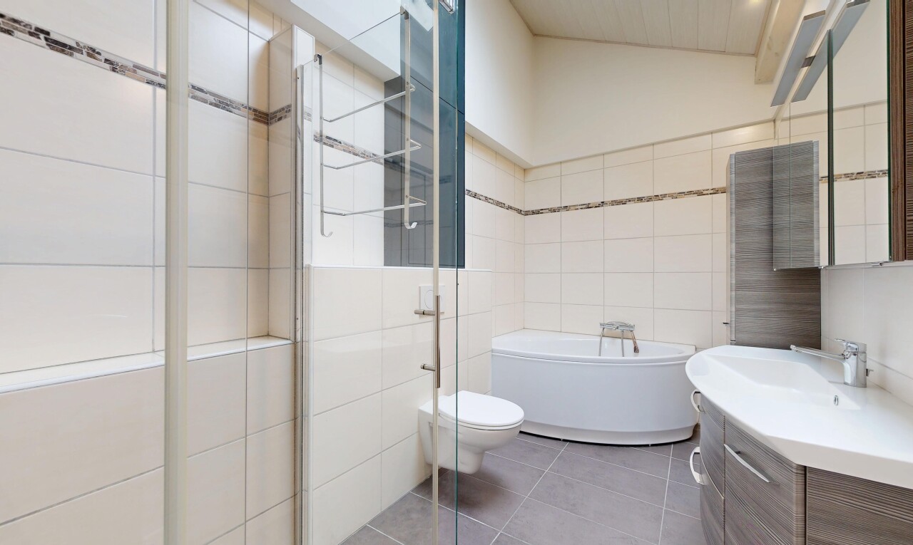 salle de bains avec salle de bain complète, lavabo (ou coiffeuse selon le contexte), miroir, tile wall, et mur en carrelage