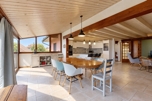 salle à manger avec éclairage suspendu, high end ceiling, light floor, drywall, et cloison sèche