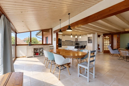 salle à manger avec éclairage suspendu, high end ceiling, light floor, drywall, et cloison sèche