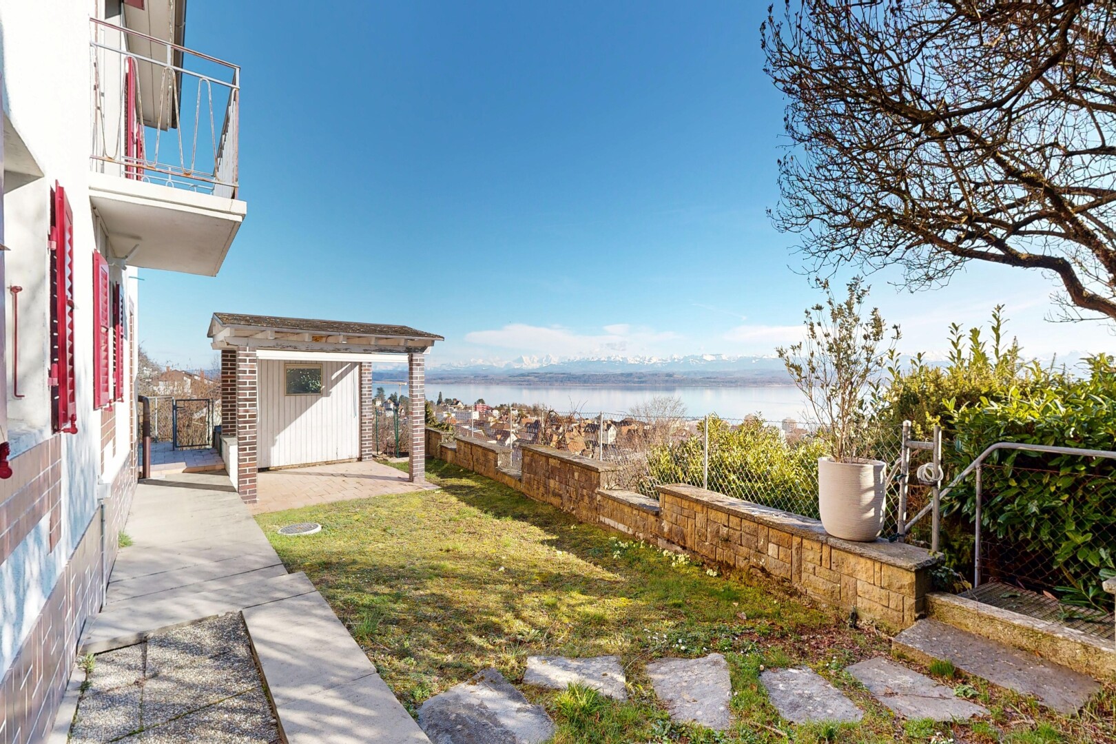 garden featuring a water view, a storage shed, a patio, and a fenced backyard