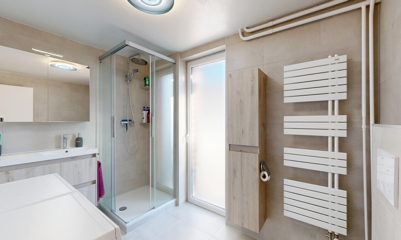 full bath with a stall shower, vanity, and a towel warming rack