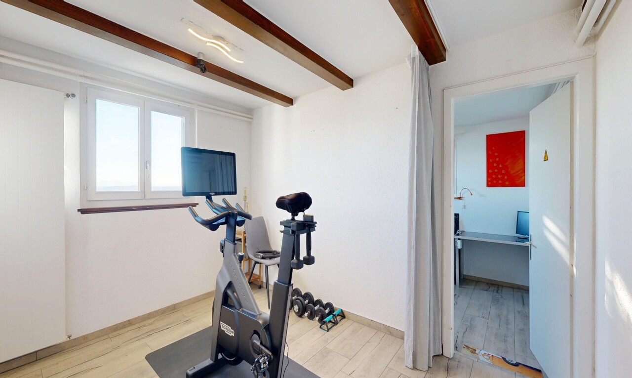 gym with beamed ceiling and light wood finished floors