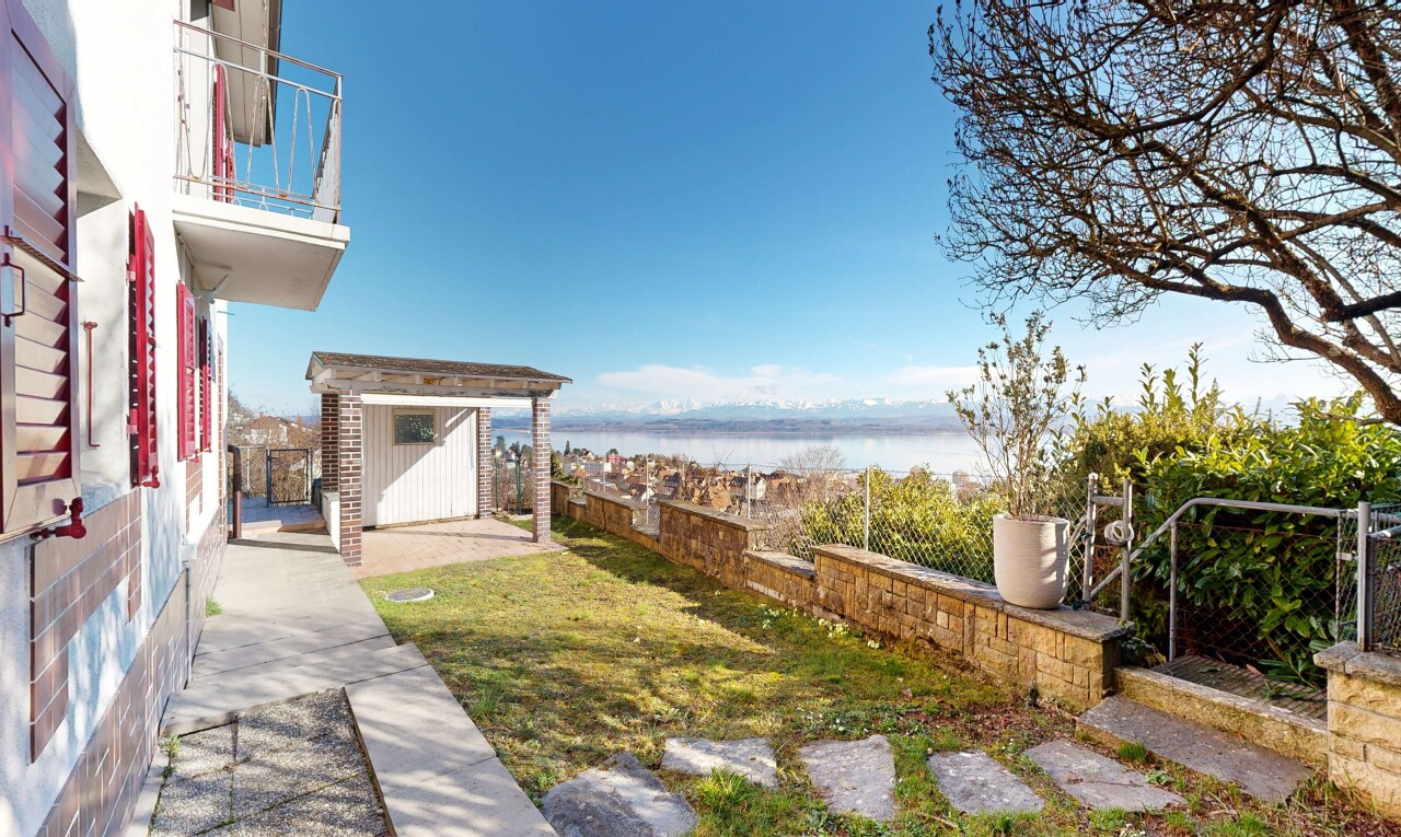 garden featuring a water view, a storage shed, a patio, and a fenced backyard