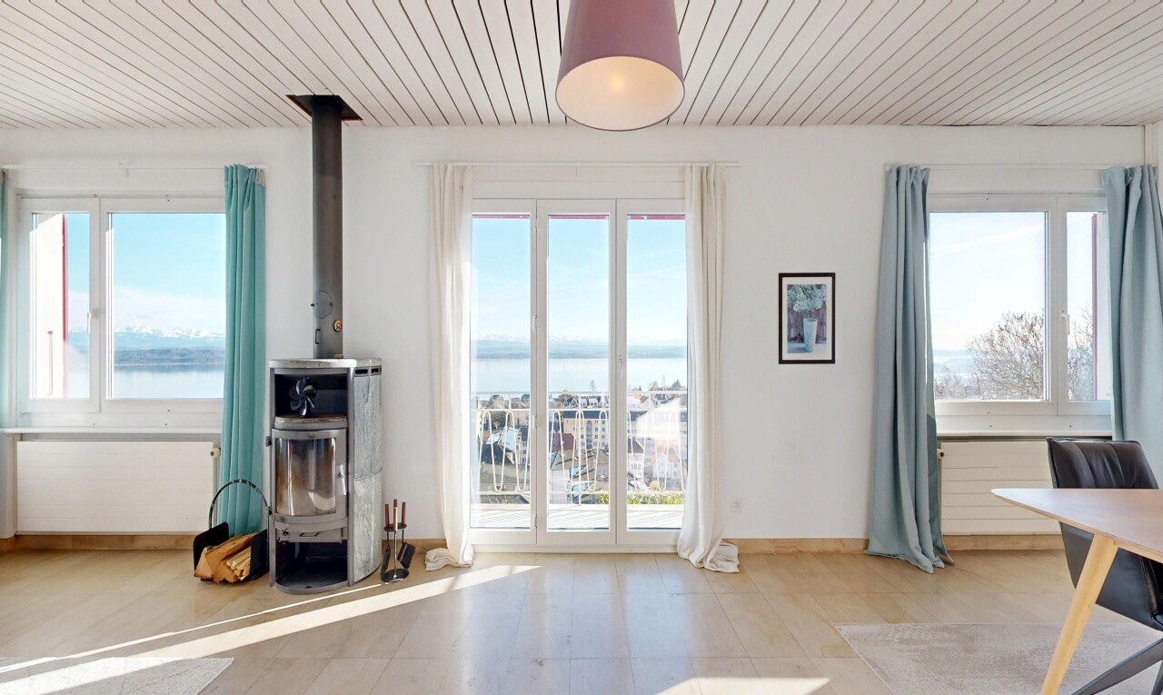 living area featuring wooden ceiling, a water view, healthy amount of natural light, and a wood stove