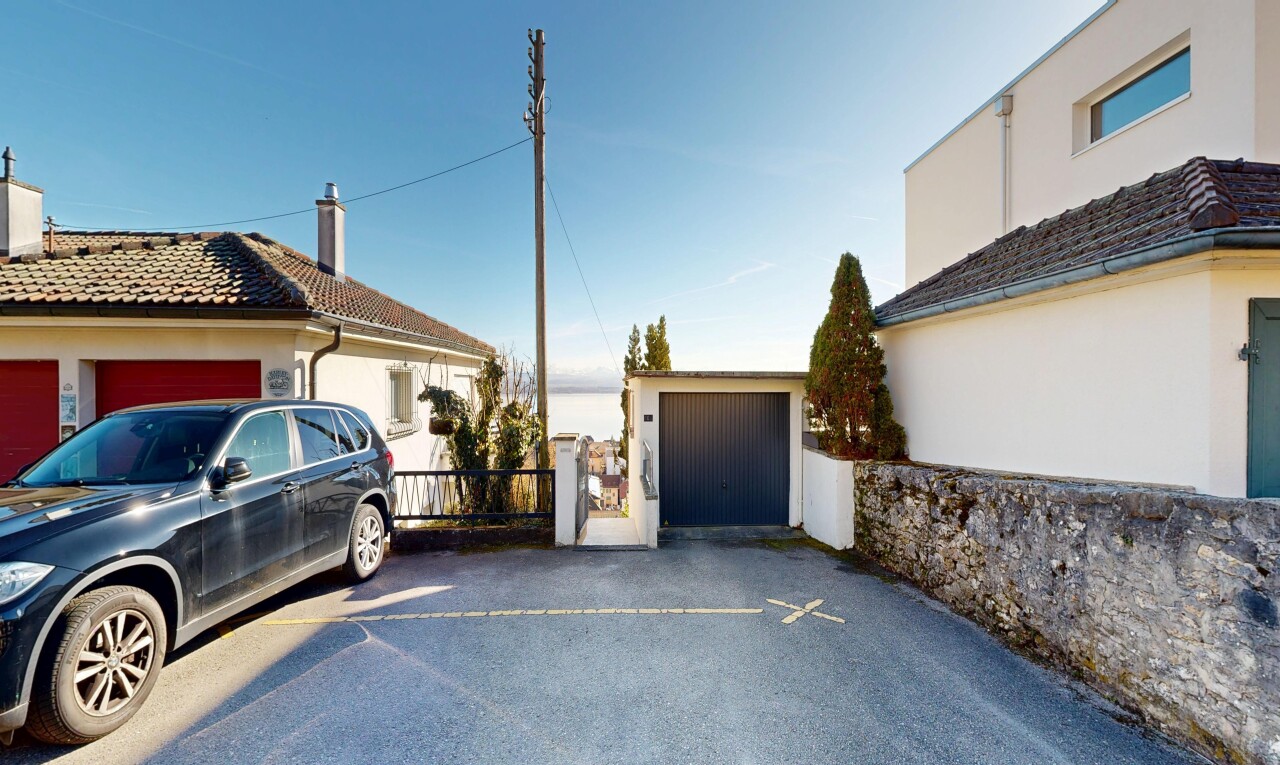 terrace featuring a garage, an outdoor structure, and driveway