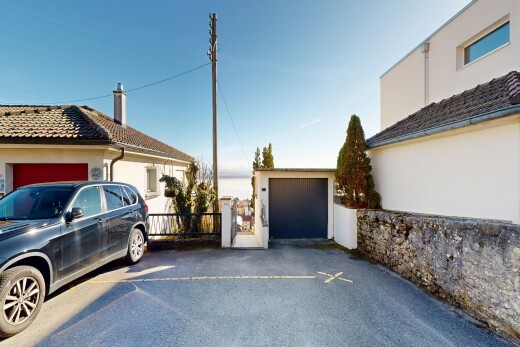 terrace featuring a garage, an outdoor structure, and driveway