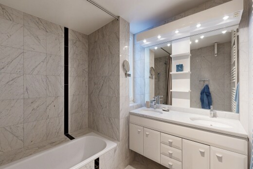 bathroom featuring a towel warming rack, double vanity, a garden tub, tile walls, and radiator heating unit